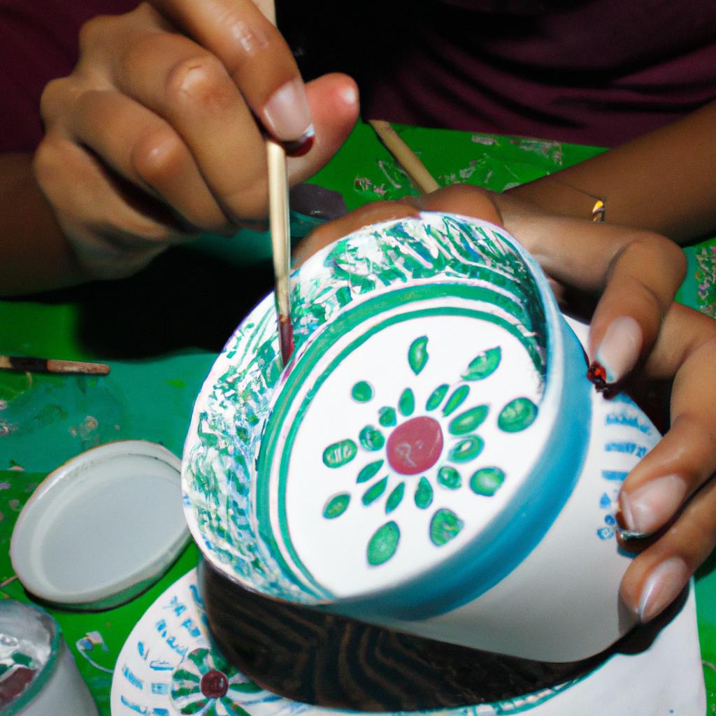 Person painting intricate pottery designs